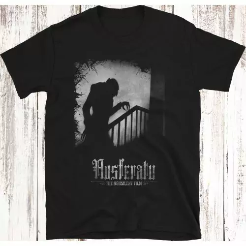 Umarme die Eleganz der Schatten: Schmiege dich an die exklusive T-Shirt mit der ikonischen Silhouette von Nosferatu aus dem stummen Meisterwerk von 1922; ein Ikone des stummen Films, schattige Kunstfertigkeit und Komfort treffen auf Horror. Bestelle jetzt