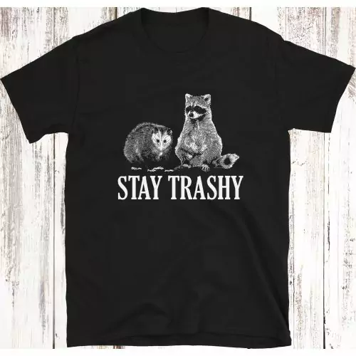 Verleih deinem Stil eine Prise Verspieltheit mit unserem "Stay Trashy Opossum & Raccoon" Lustiges Meme T-Shirt, das ein entzückendes Duo und den frechen Slogan "STAY TRASHY" zeigt.