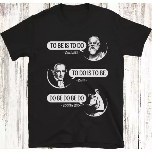 Zeige deine philosophische und humorvolle Seite mit unserem T-Shirt 'To Be Is To Do -ODER- Do Be Do Be Do,' das Socrates, Kant und Scooby-Doo zeigt. Hergestellt mit einer Mischung aus Intellekt und Humor, ist dieses Shirt perfekt sowohl für Philosophie-En